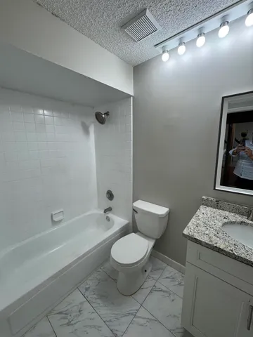 a white toilet sitting next to a bath tub