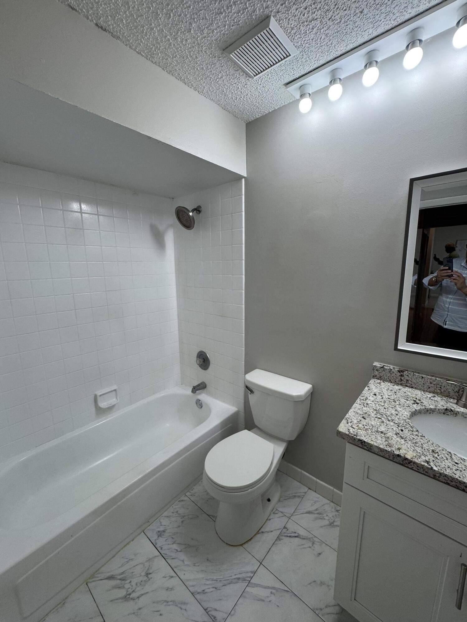 9777 Nickels Boulevard, Unit 705 Boynton Beach, FL 33436 - Photo 22 of 41 a white toilet sitting next to a bath tub