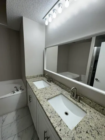 a bathroom with a granite countertop sink and a mirror
