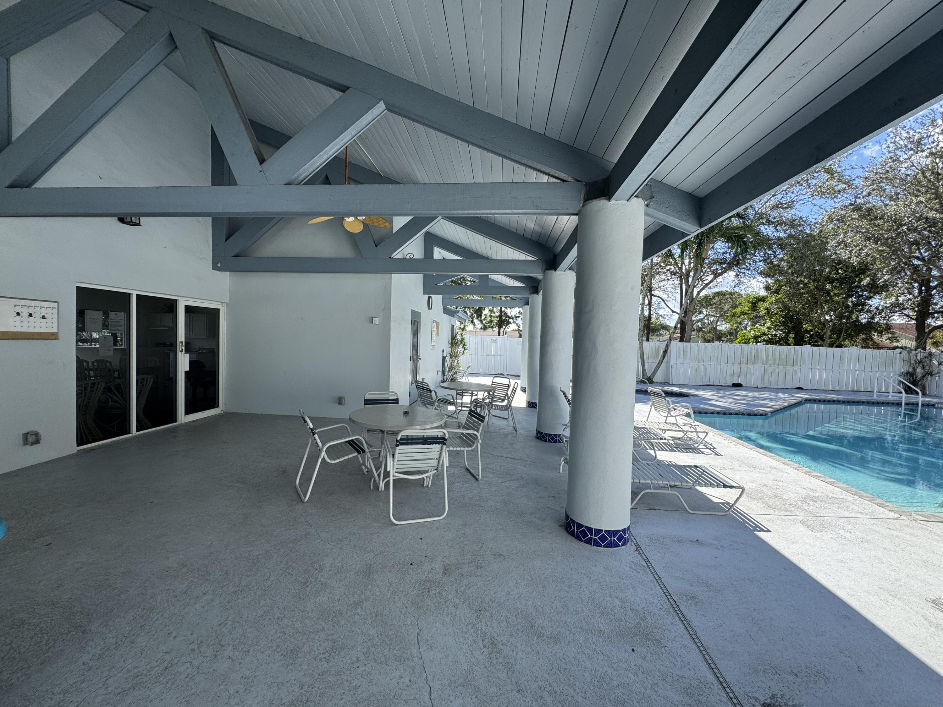 9777 Nickels Boulevard, Unit 705 Boynton Beach, FL 33436 - Photo 40 of 41 a view of a patio with table and chairs and potted plants