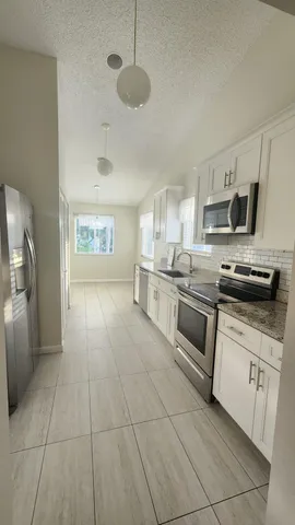 a bathroom with a granite countertop sink and a bathtub