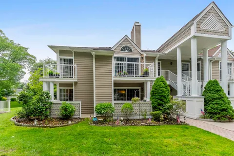 a front view of a house with a yard and potted plants