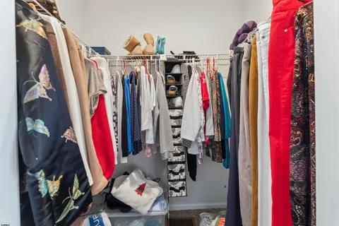 a view of walk in closet with clothes