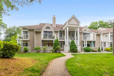 a front view of a house with a yard and potted plants