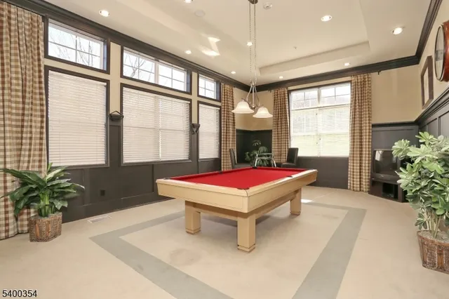 a room with pool table and windows