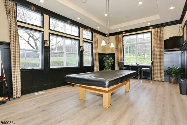 a room with pool table and windows