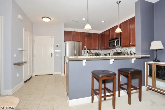 a kitchen with stainless steel appliances granite countertop a refrigerator and a stove top oven