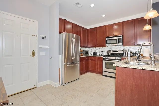 a kitchen with stainless steel appliances granite countertop a stove a sink and a microwave