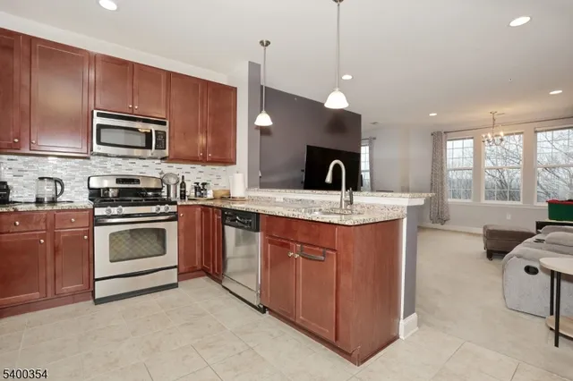 a kitchen with granite countertop wooden cabinets and a stove top oven