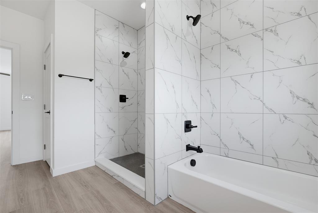 512 South O Connor Road Irving, TX 75060 - Photo 16 of 21 Bathroom featuring a walk-in shower with a dark gray base and white marble-look wall tiling