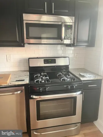 a stove top oven sitting inside of a kitchen