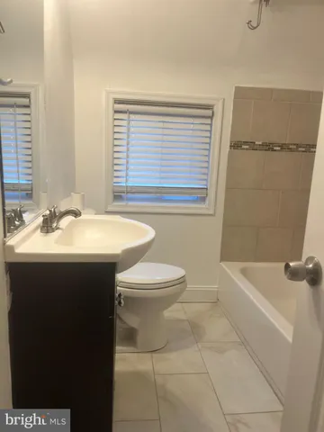 a bathroom with a sink a toilet and bathtub