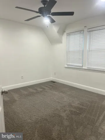 an empty room with a windows and ceiling fan