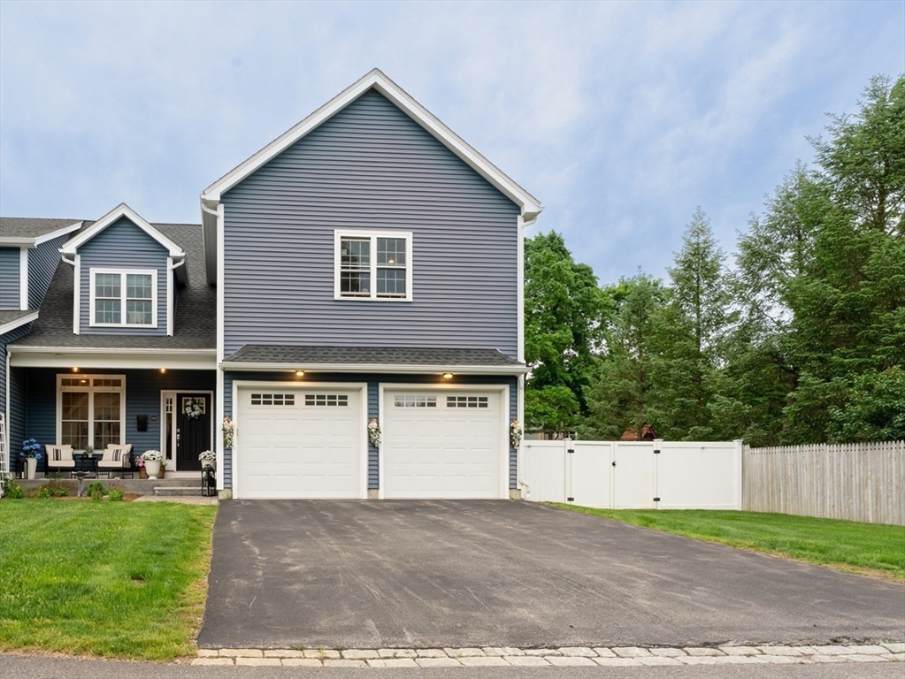 38 Cherry Street, Unit B Hudson, MA 01749 - Photo 2 of 33 a front view of a house with a yard and garage