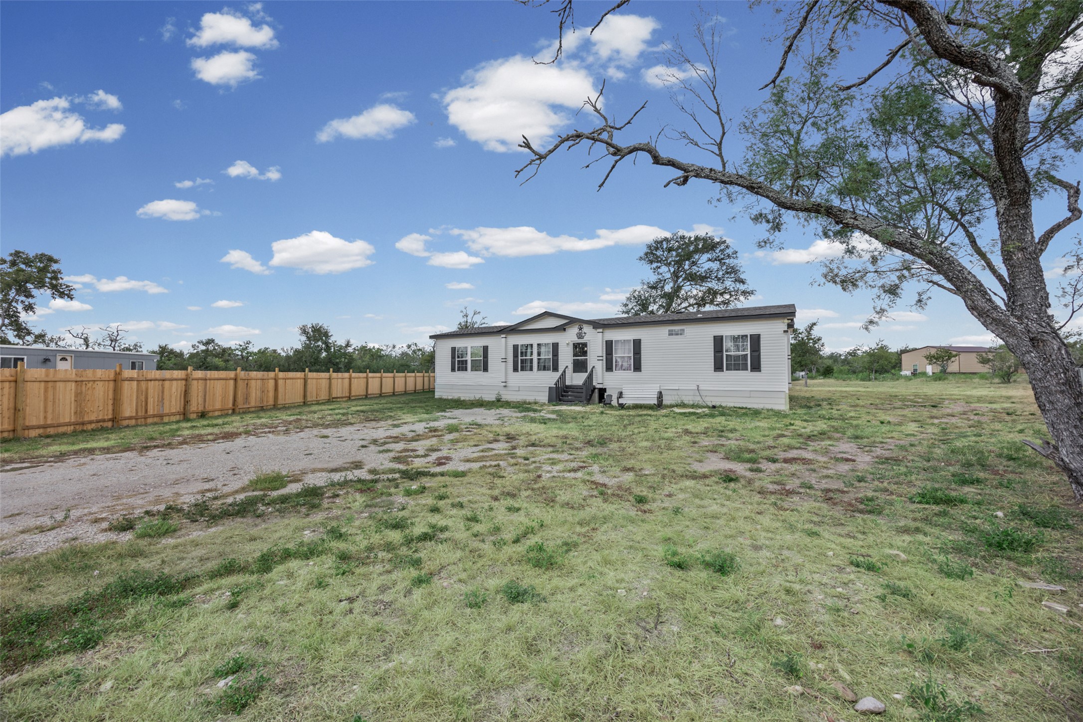 120 Mimosa Road Dale, TX 78616 - Photo 1 of 21 A manufactured home with a spacious yard and newly installed wooden fence offers private outdoor living.