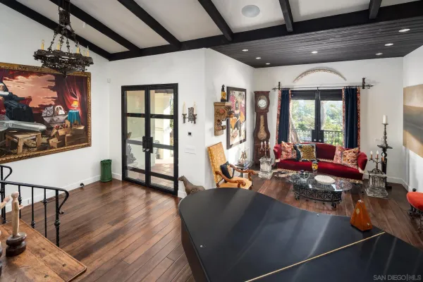 a living room with furniture a wooden floor and next to a window