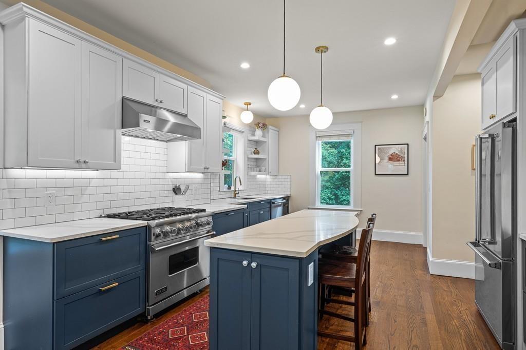 125 Walnut Street Dedham, MA 02026 - Photo 19 of 37 a kitchen with stainless steel appliances a stove a sink dishwasher a refrigerator a kitchen island with wooden cabinets and floor