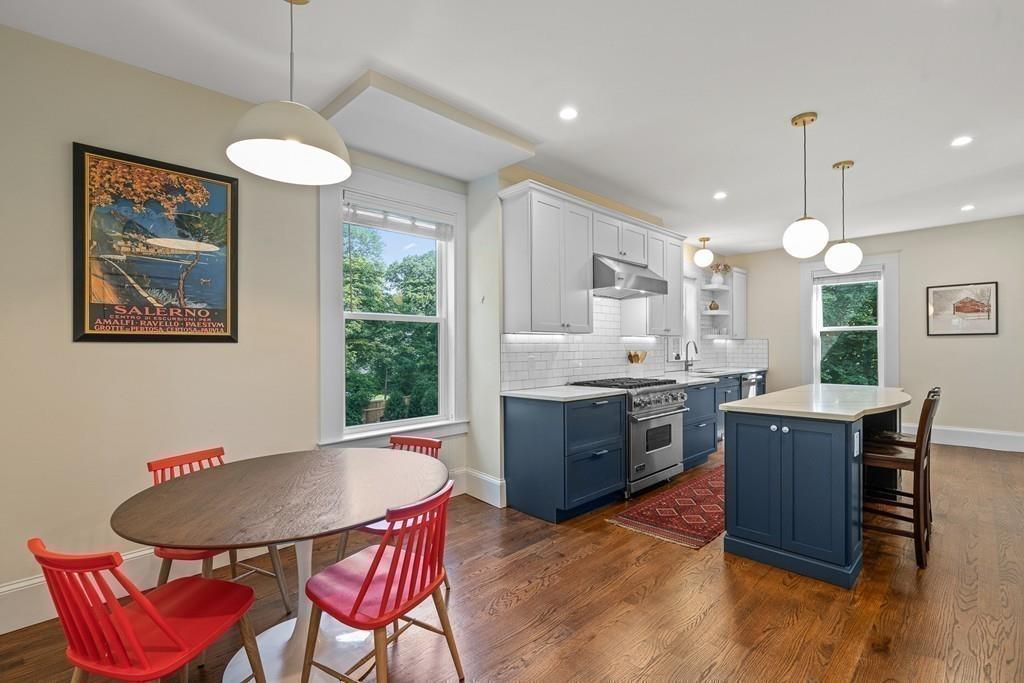 125 Walnut Street Dedham, MA 02026 - Photo 20 of 37 a kitchen with stainless steel appliances kitchen island granite countertop a stove a sink a refrigerator a stove a dining table and chairs