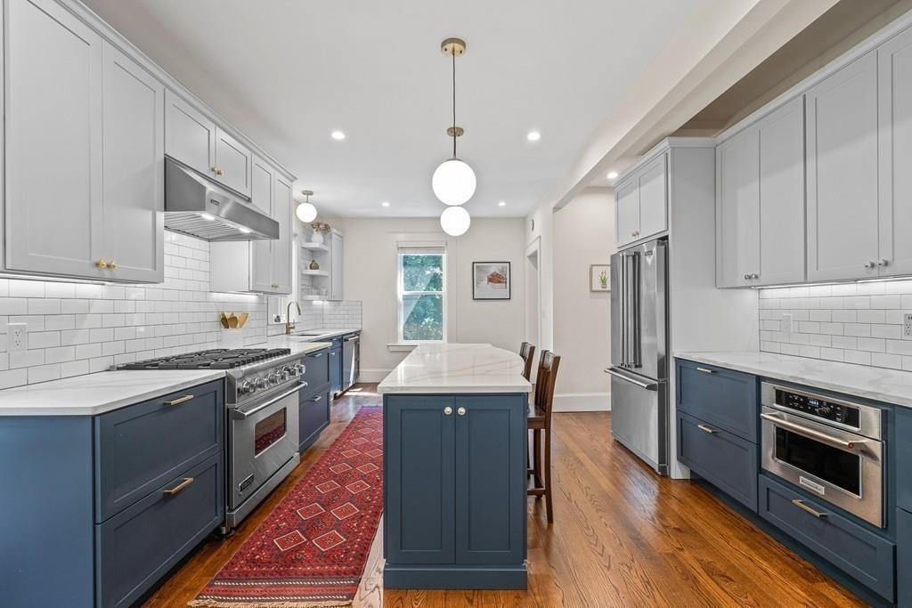 125 Walnut Street Dedham, MA 02026 - Photo 23 of 37 a kitchen with stainless steel appliances granite countertop a stove top oven a sink dishwasher and a refrigerator with wooden floor