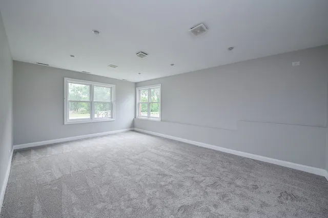 an empty room with a window and a ceiling fan