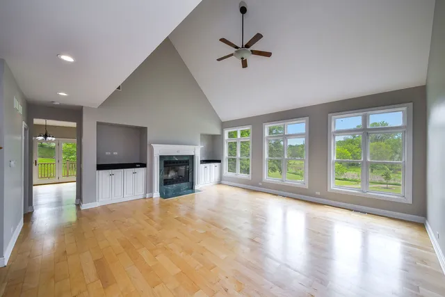 a view of empty room with wooden floor and fireplace