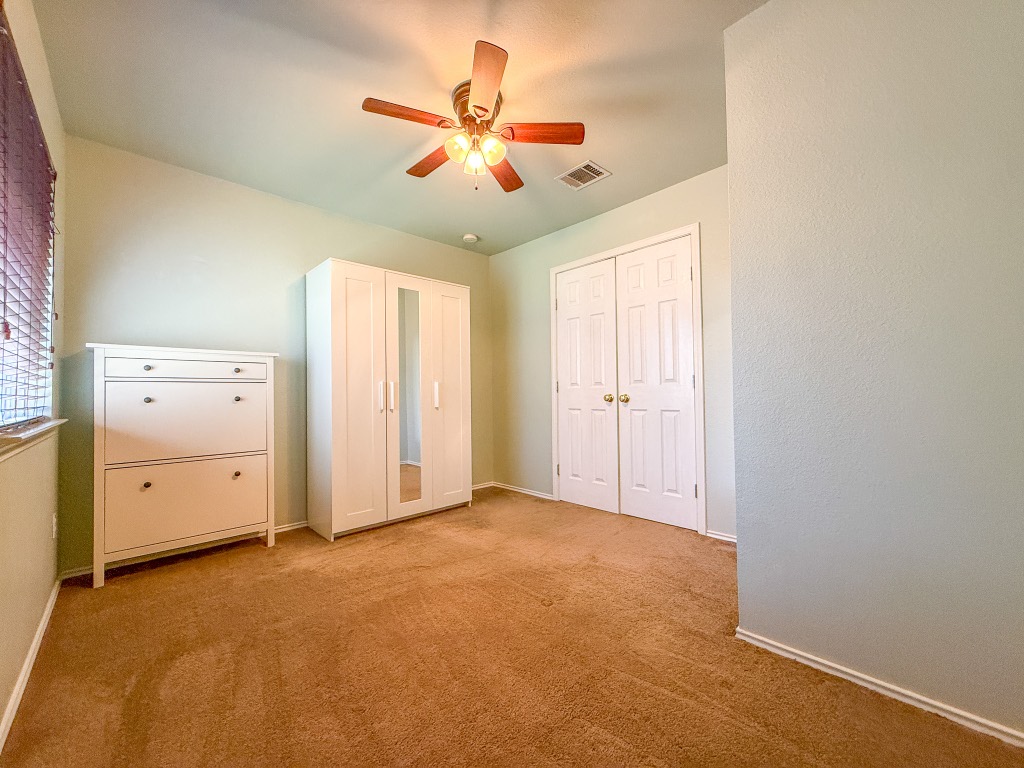 11101 Franklins Tale Loop Austin, TX 78748 - Photo 32 of 39 Unfurnished bedroom with a ceiling fan, light colored carpet, and a closet