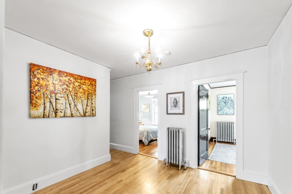 115 Sumner Road Brookline, MA 02445 - Photo 14 of 25 a view of a hallway with wooden floor and a living room