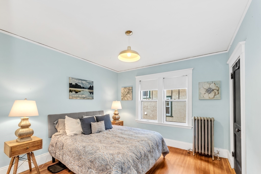 115 Sumner Road Brookline, MA 02445 - Photo 16 of 25 a bedroom with a bed a wall painting and a window