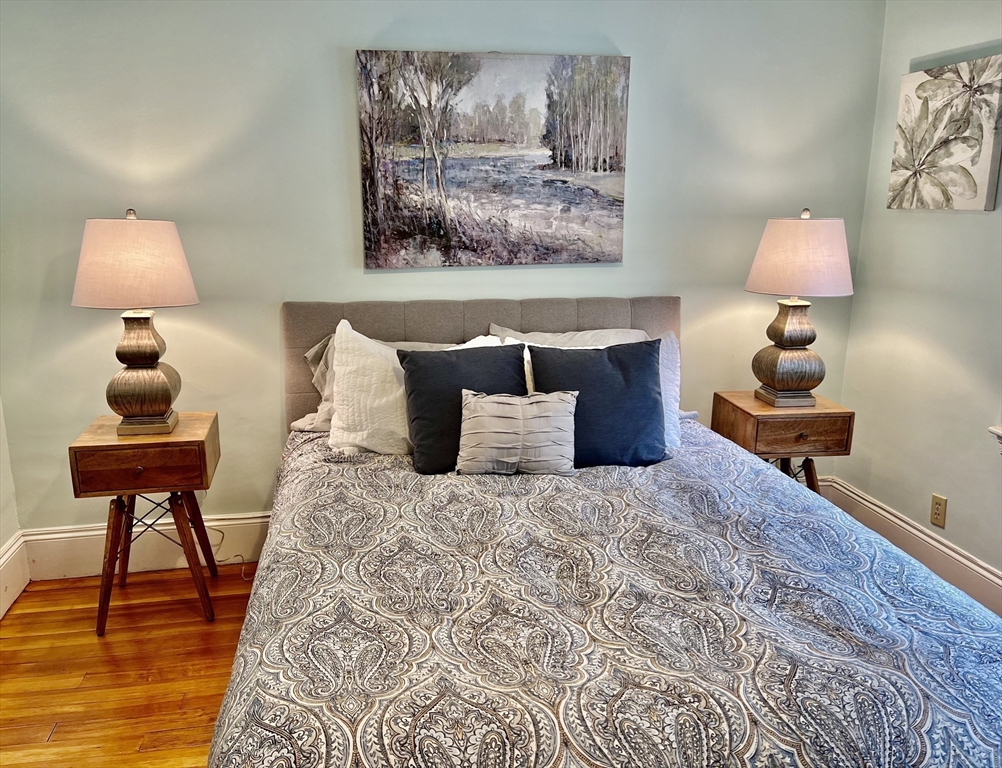 115 Sumner Road Brookline, MA 02445 - Photo 17 of 25 a bed room with a bed and a lamp