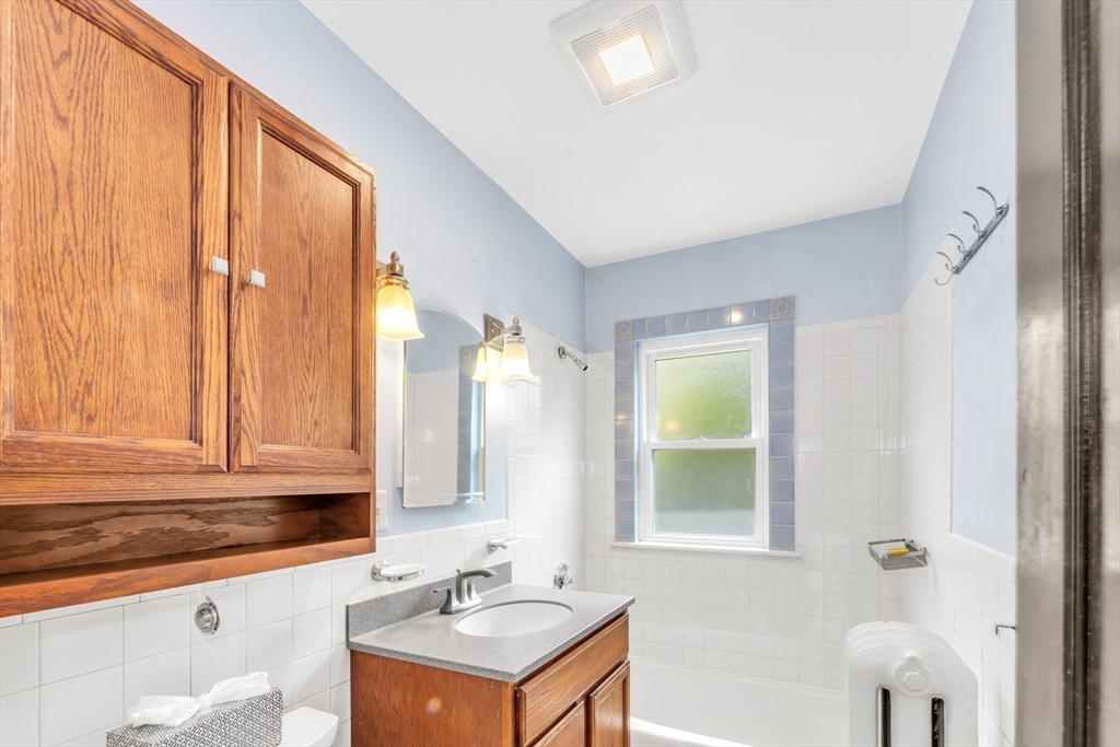 115 Sumner Road Brookline, MA 02445 - Photo 19 of 25 a bathroom with a granite countertop sink and a mirror