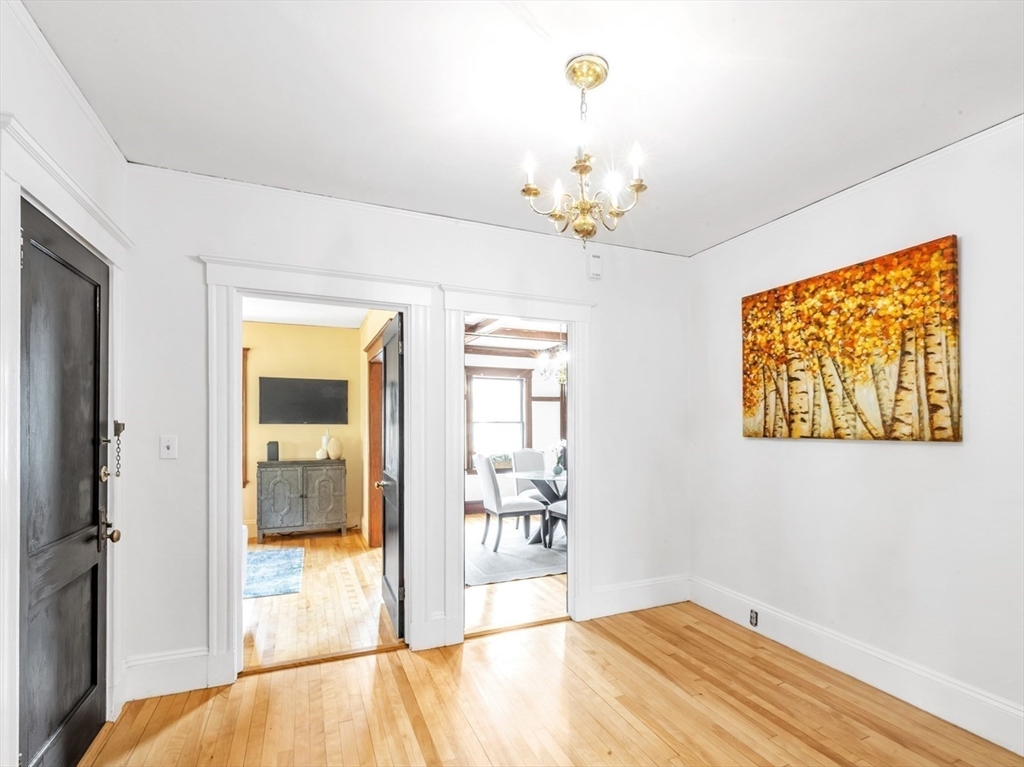 115 Sumner Road Brookline, MA 02445 - Photo 4 of 25 a bedroom with a bed and a chandelier