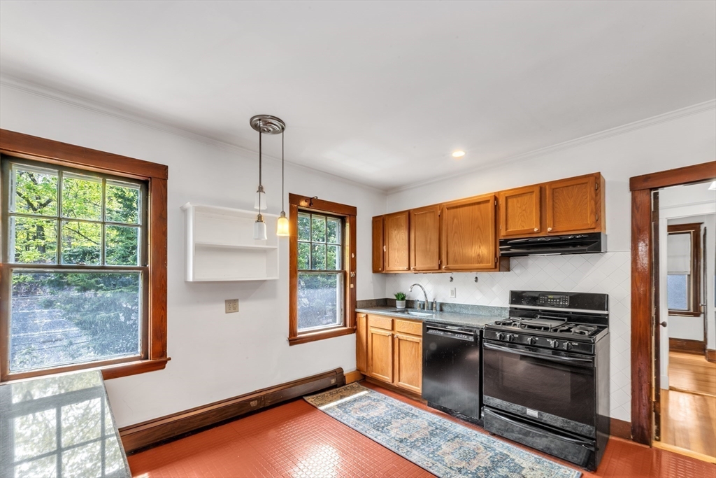 115 Sumner Road Brookline, MA 02445 - Photo 10 of 25 a kitchen with stainless steel appliances granite countertop a stove a sink and a refrigerator