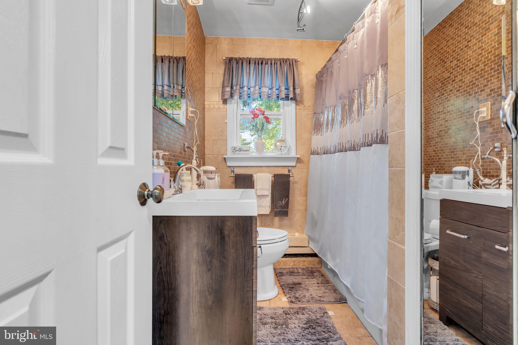 80 Locust Avenue Hamilton, NJ 08620 - Photo 14 of 24 a bathroom with a sink a mirror and a shower