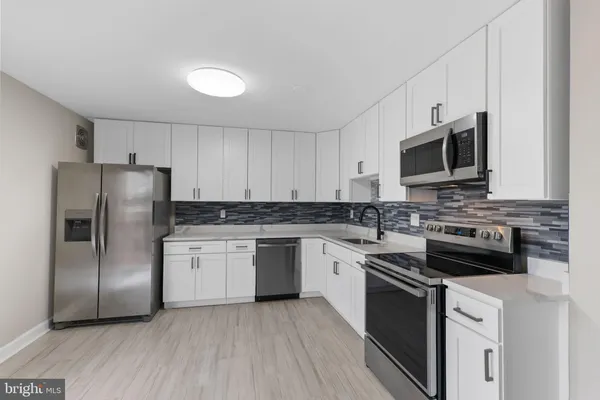 a kitchen with stainless steel appliances granite countertop a refrigerator stove a sink and microwave