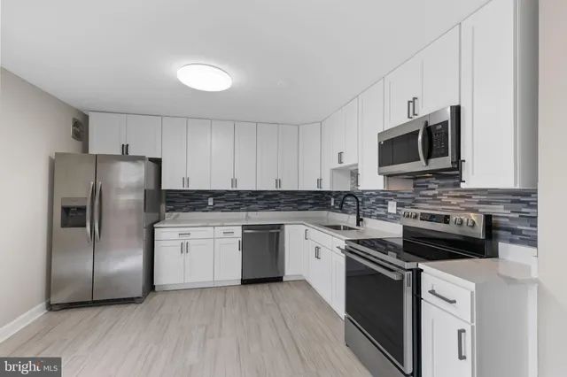 a kitchen with stainless steel appliances granite countertop a refrigerator stove a sink and microwave