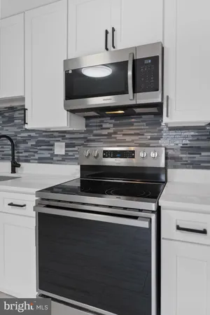 a kitchen with stainless steel appliances a stove a microwave sink and cabinets