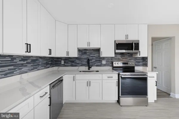 a kitchen with cabinets stainless steel appliances and a sink