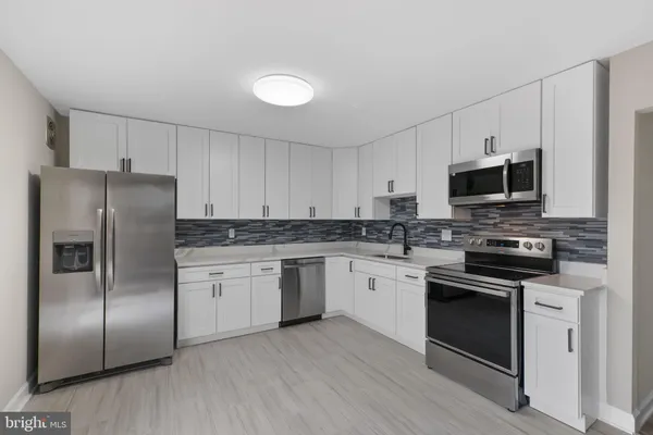 a kitchen with granite countertop a refrigerator stove and microwave
