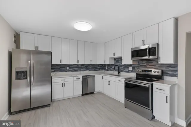 a kitchen with granite countertop a refrigerator stove and microwave