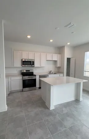 a kitchen with a sink a counter top space stainless steel appliances and cabinets