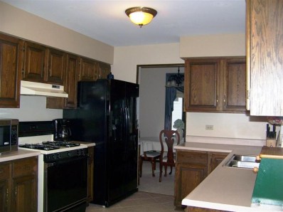 5046 89th Place Crown Point, IN 46307 - Photo 7 of 10 a kitchen with a refrigerator and a stove top oven