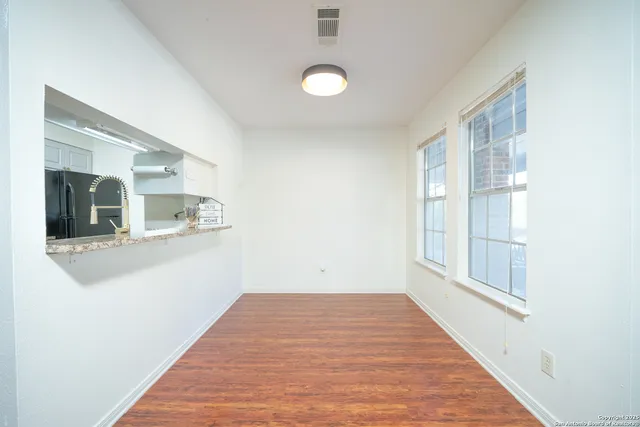 a view of a livingroom with wooden floor and a large window
