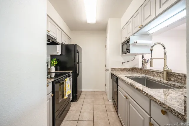 a kitchen with granite countertop a sink stove and refrigerator