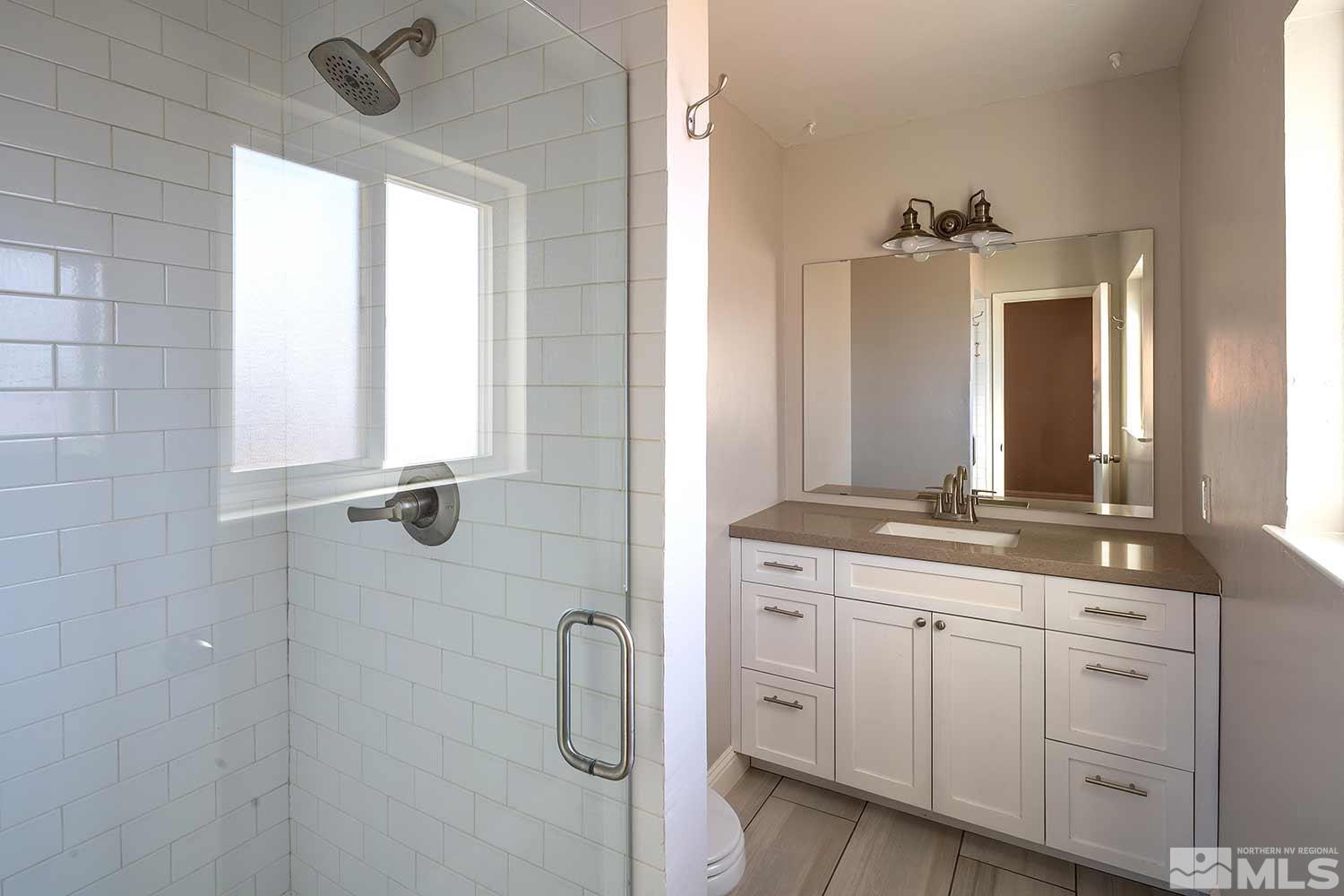 1465 West 12th Street Reno, NV 89503 - Photo 23 of 40 a bathroom with a double vanity sink a mirror and a shower