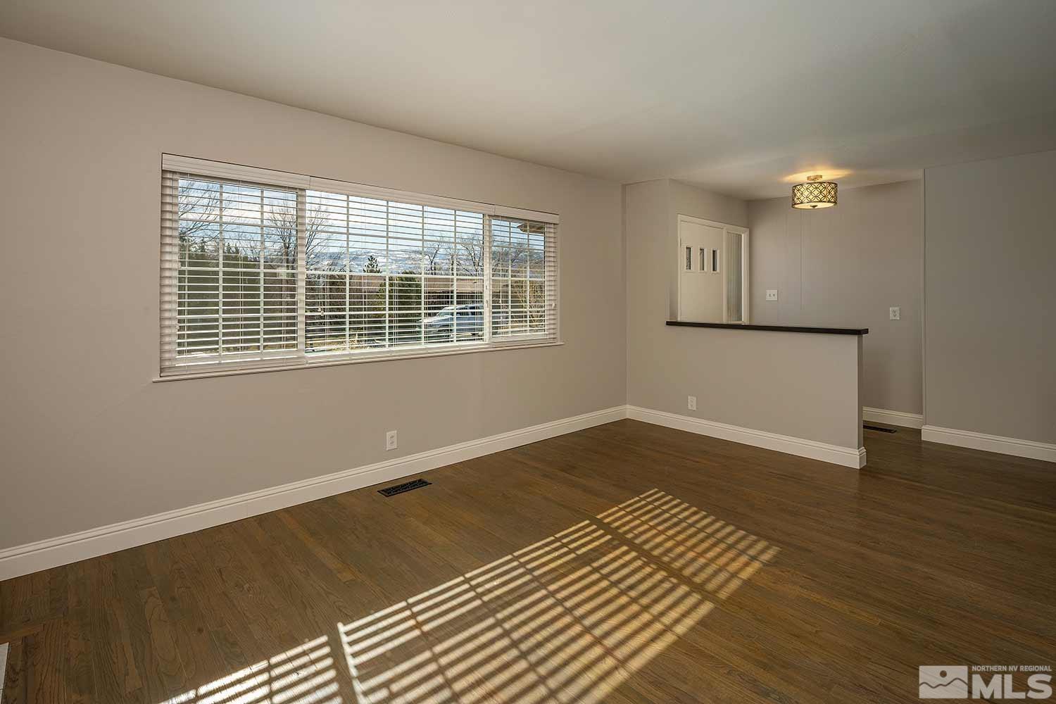1465 West 12th Street Reno, NV 89503 - Photo 9 of 40 a view of an empty room with wooden floor and a window