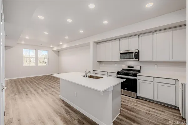 a kitchen that has a sink and a stove top oven