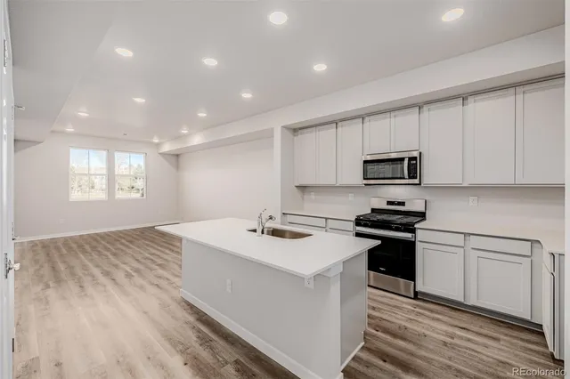 a kitchen that has a sink and a stove top oven
