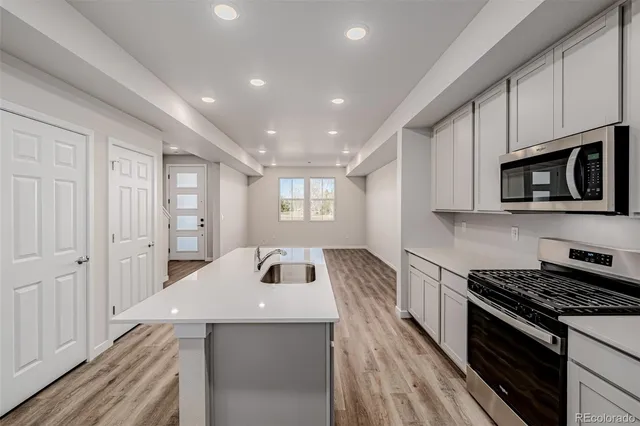 a kitchen with sink a microwave and cabinets