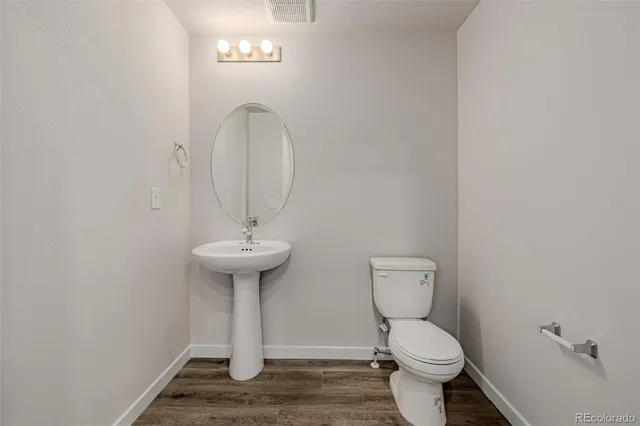 a bathroom with a toilet a sink and mirror