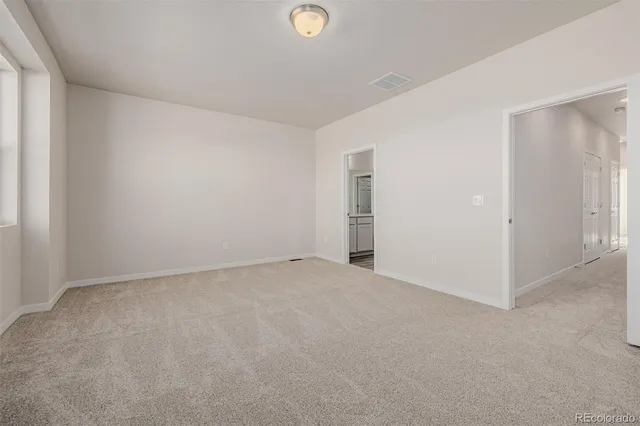 an empty room with closet and windows